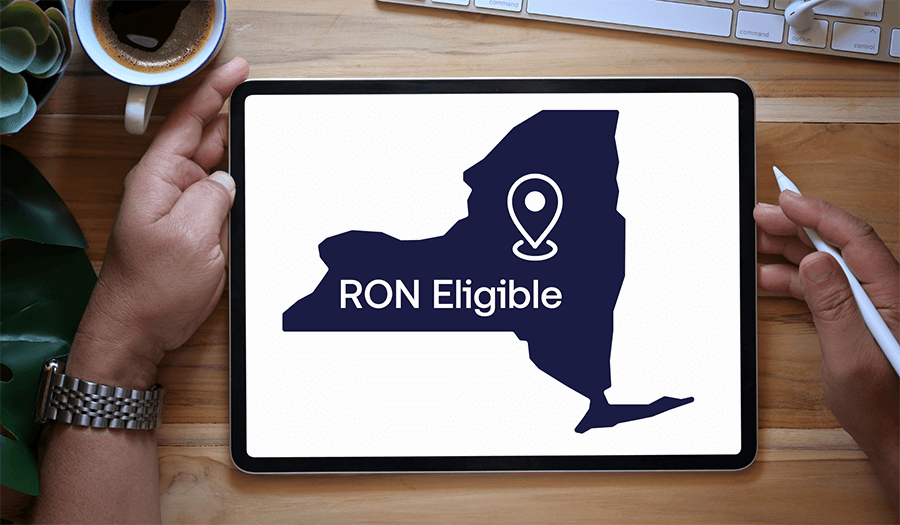 iPad screen is displaying the outline of New York state with a pin in the middle. Underneath the pin the words read, 